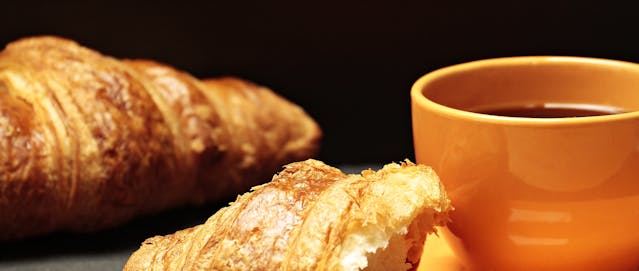 Falsche Hotelrechnung (12.12.2025) zwei Croissants, die zusammen mit einer Tasse dunklen Kaffee ein Frühstück darstellen