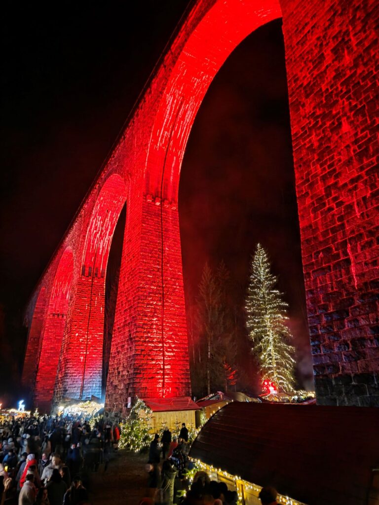 Rot beleuchteter Weihnachtsmarkt Ravennaschlucht bei Nacht.