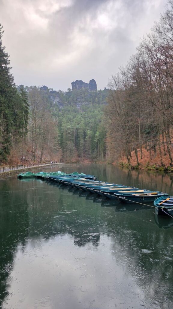 Silvester in Prag (04.01.2026) Mehrere grüne Ruderboote auf einem zugefrorenem See, umgeben von Bäumen und Felsen