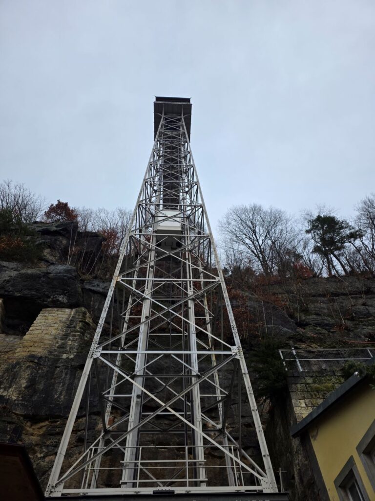 Silvester in Prag (04.01.2026) ein hoher, freistehender stählerner Aufzugsturm neben einer Felswand
