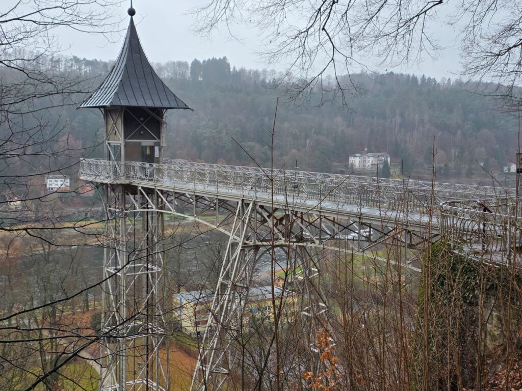 Silvester in Prag (04.01.2026) ein hoher, freistehender stählerner Aufzugsturm von oben neben einer Felswand und im Hintergrund ein Fluss im Tal