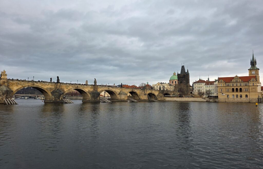 Silvester in Prag (04.01.2026) Steinbrücke mit Rundbögen, die Karlsbrücke in Prag, die über die Moldau führt, mit angrenzenden historischen Gebäuden