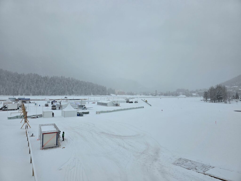 Glacier Express (01.02.2026) Vereister und verschneiter St. Moritzsee, auf dem mehrere Zelte und Zäune stehen, die auf ein Event hindeuten